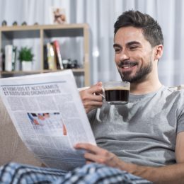 man laughing at newspaper