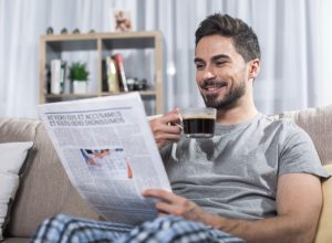 man laughing at newspaper