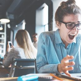 stressed out woman screams at computer, working mom