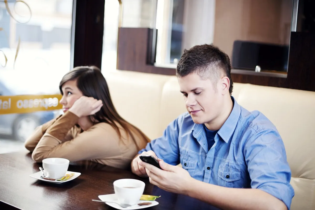 Man On His Phone in a Restaurant While on a Date Social Etiquette Mistakes
