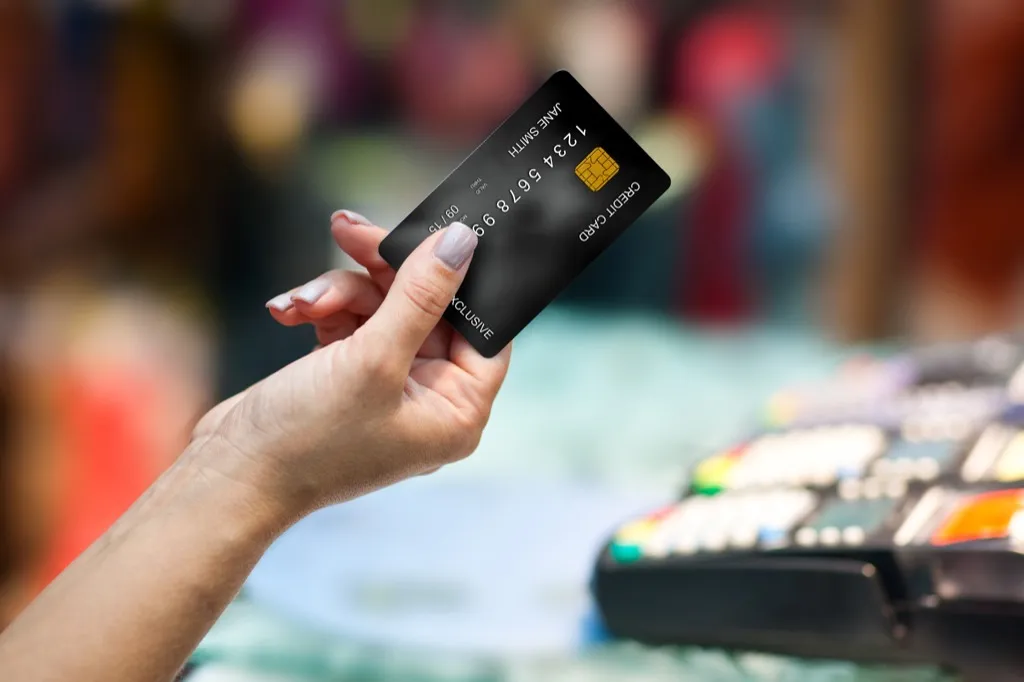 woman holding credit card Social Etiquette Mistakes