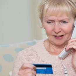 elderly woman giving credit card details by phone.