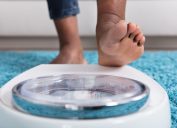 Black woman stepping on a scale to weigh herself