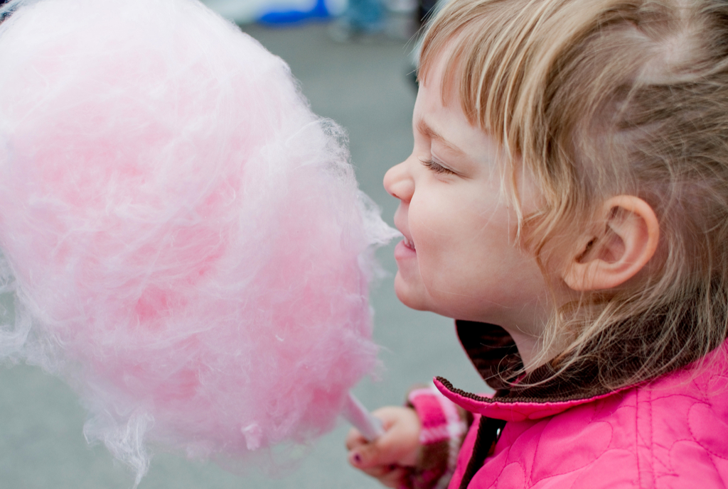 Little girl eating cotton candy