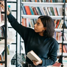 Young black woman selecting a book