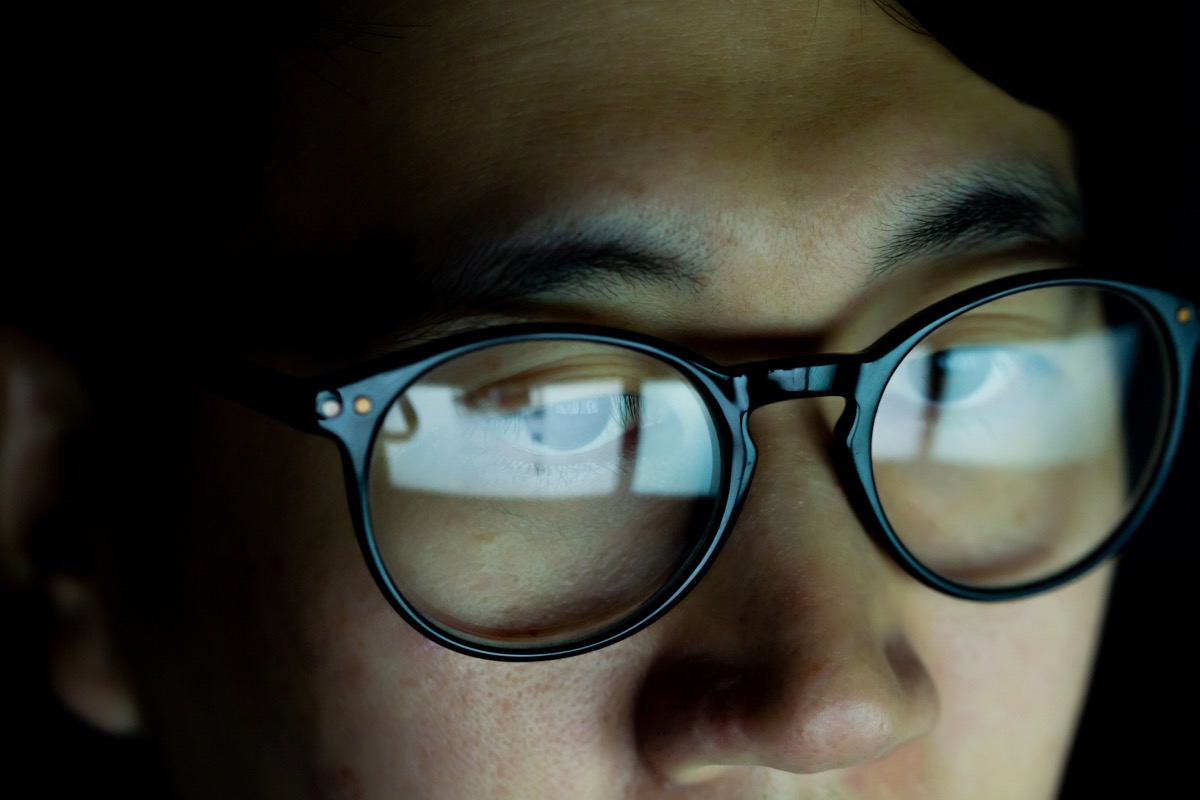 Close up of Young Asian man in glasses watching videos and surfing internet on technology device in the dark (Close up of Young Asian man in glasses watching videos and surfing internet on technology device in the dark, ASCII, 109 components, 109 byte