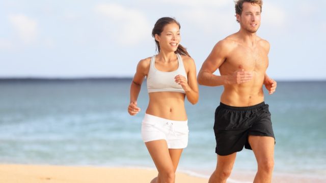 man and woman couple running at the beach man and woman exercising cardio workouts for men over 40