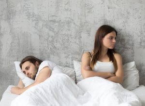 couple sitting in bed upset, stopped having sex