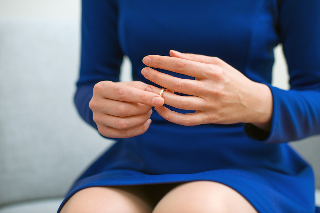woman in blue dress removing wedding ring, worst things about an empty nest