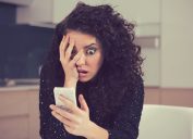 woman shocked surprised looking at phone