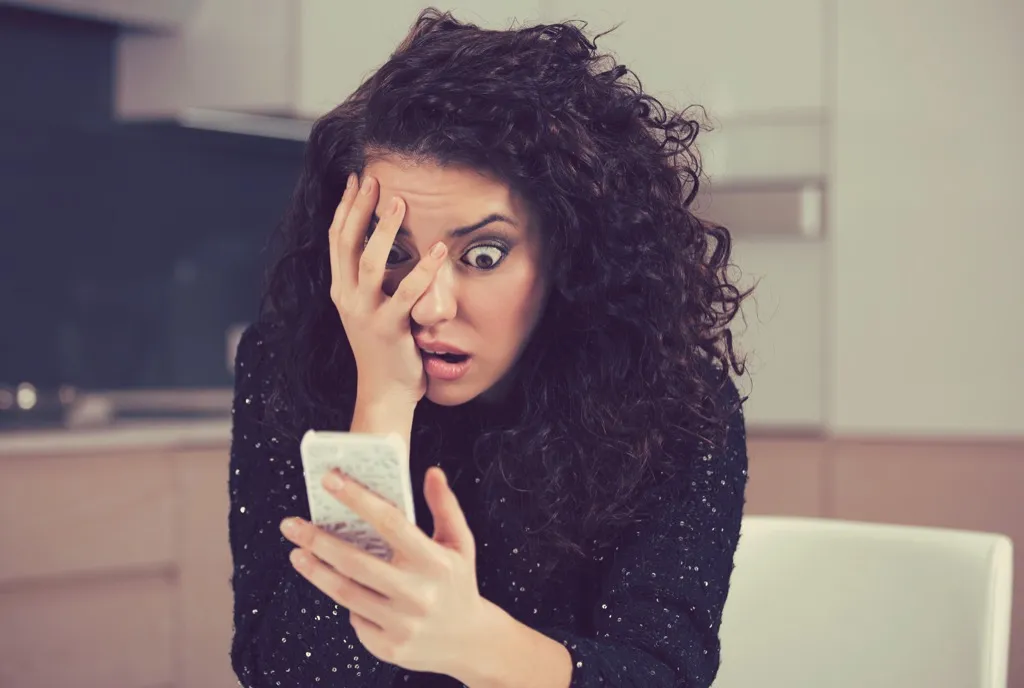 woman shocked surprised looking at phone
