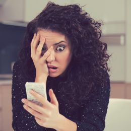 woman shocked surprised looking at phone