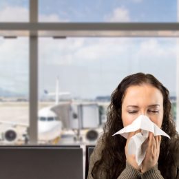 Woman sneezing at the airport.
