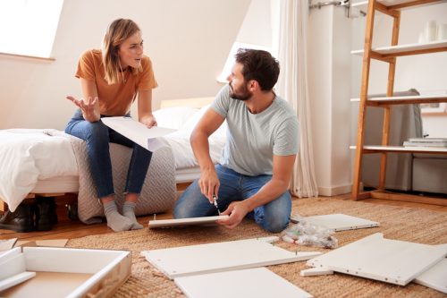 couple having argument while assembling furniture in their home