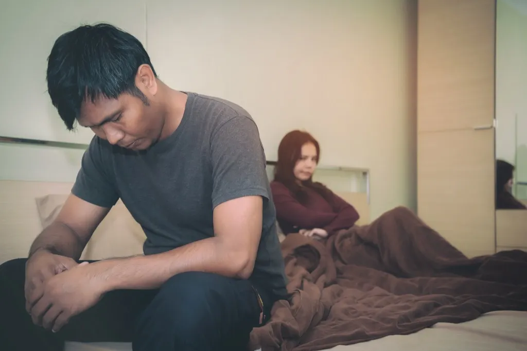 couple looking upset on the bed, signs your husband is cheating