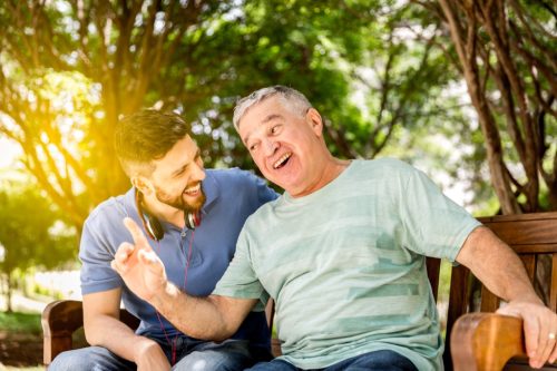dad and son laughing on a park bench, dad jokes