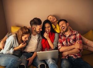 group of friends laughing at computer, bad jokes