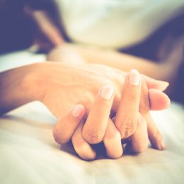 this couple holding hands on a bed implies that they're having sex!