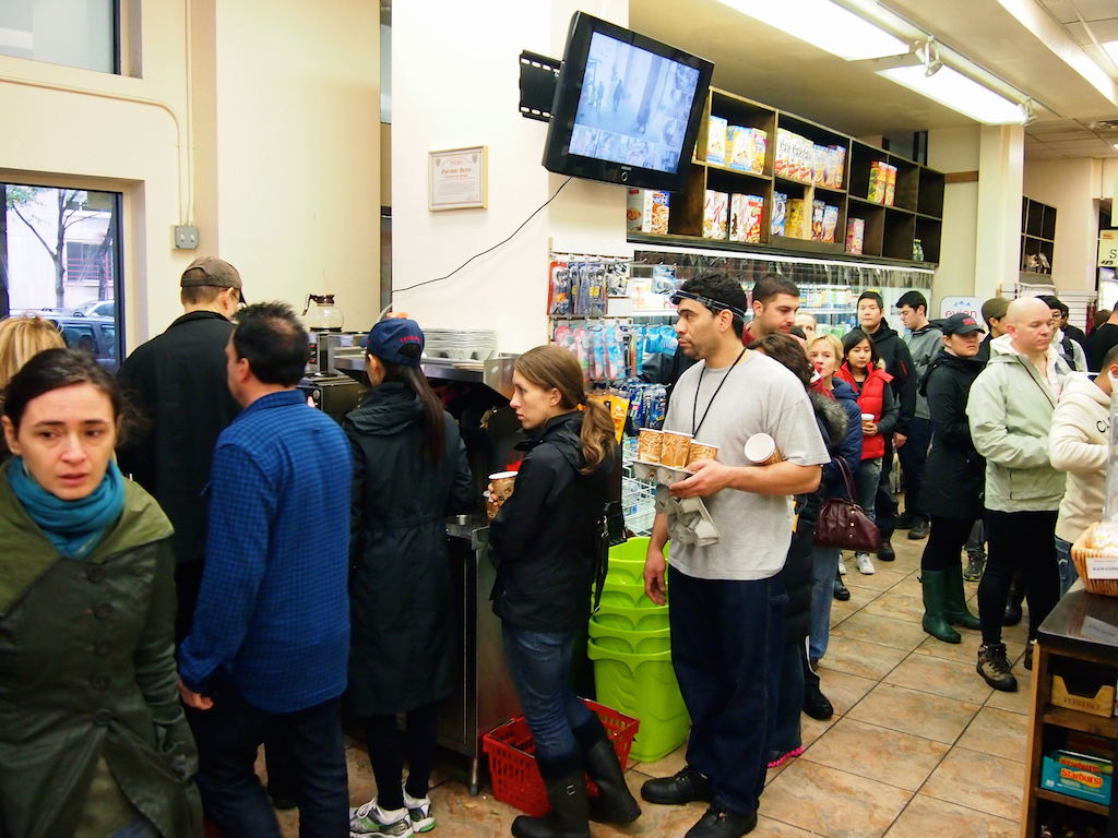 NYC residents stand in long grocery line. 