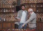 father and son pointing at table soccer game