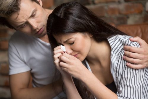 girl crying with guy consoling her