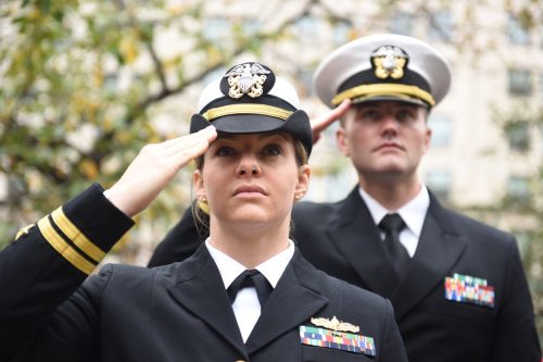 united states army members, one man and one woman, in dress uniform, saluting