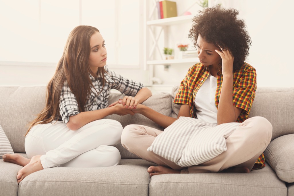 woman listens to upset friend on couch