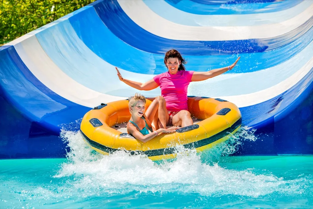 mother and daughter sliding down waterslide, water park