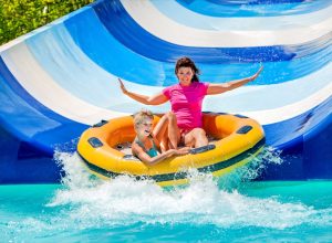 mother and son sliding down waterslide, water park