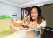 Woman overeating, eating in the fridge snacking