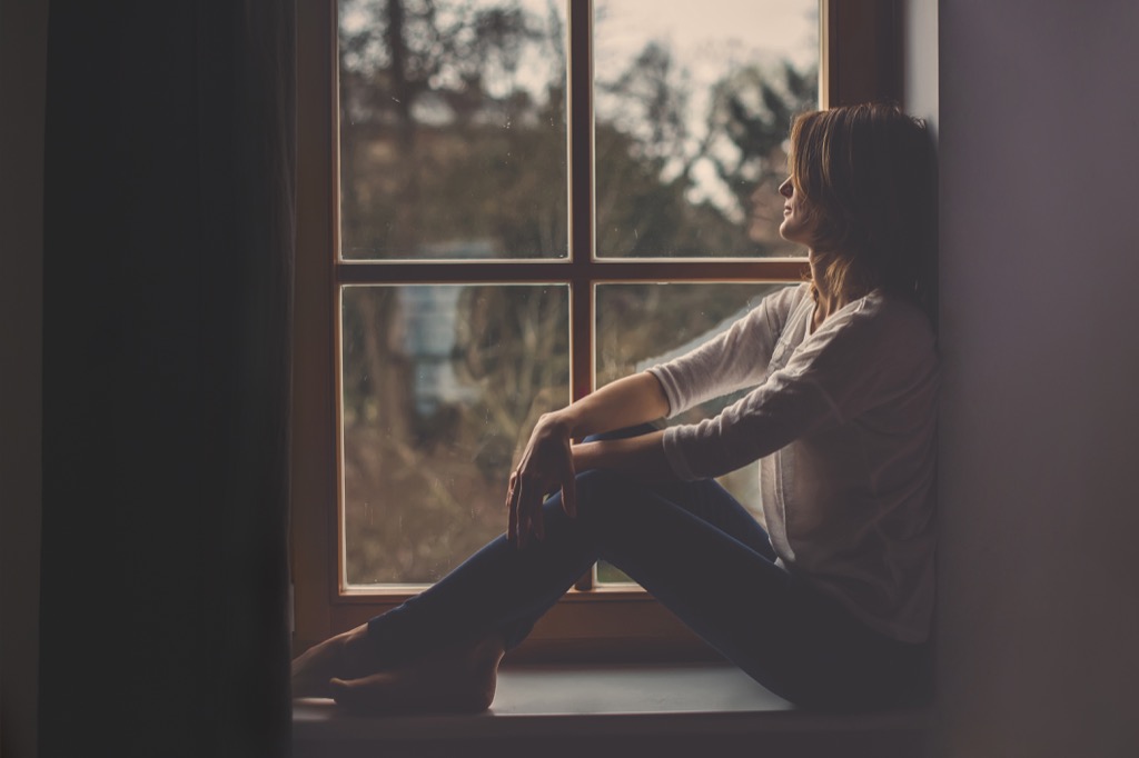 woman wistfully gazing out a window