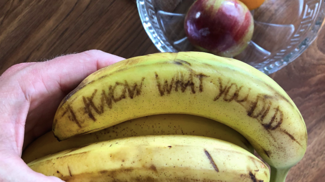 man writes messages on bananas