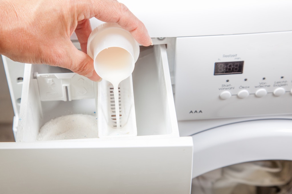 pouring detergent into washing machine