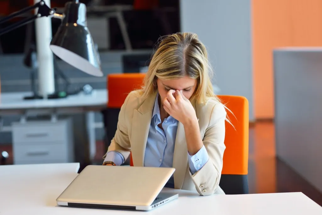 frustrated woman in office in front of laptop - commonly misused phrases