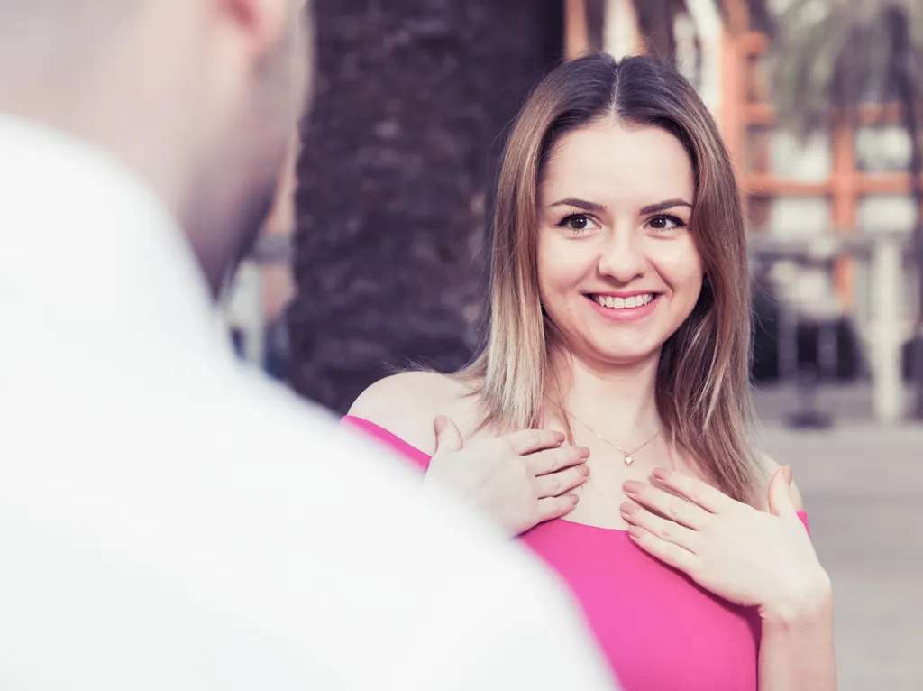 woman pointing to herself in front of a man, how to tell if a girl likes you
