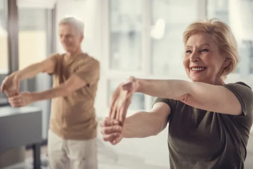 Adulții în vârstă sănătoși se întind și fac exerciții fizice.