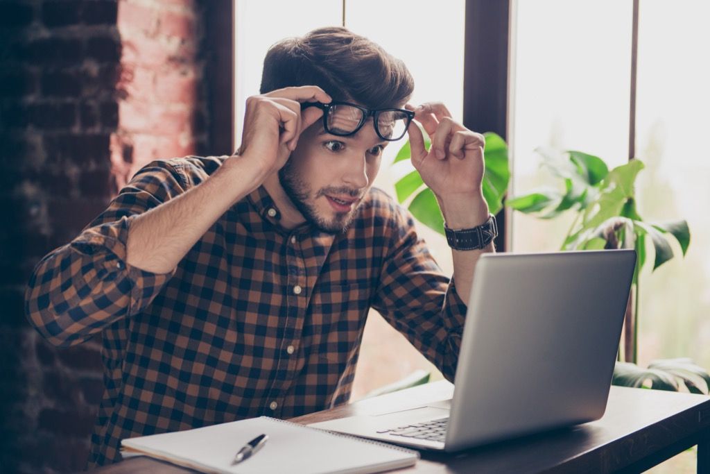 man looking shocked at laptop computer