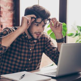 man looking shocked at laptop computer