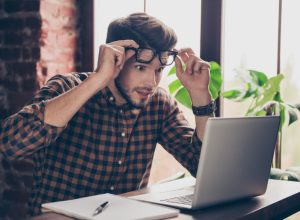 man looking shocked at laptop computer
