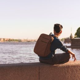 man sitting alone by a european river