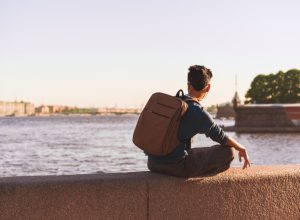 man sitting alone by a european river