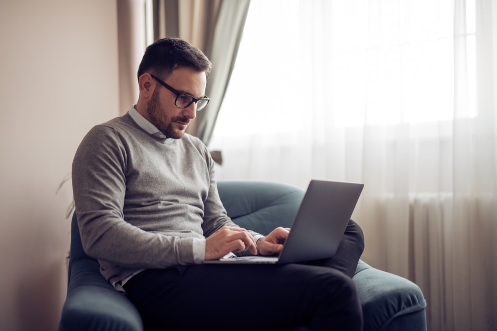 man sitting with laptop on lap, healthy sex after 40