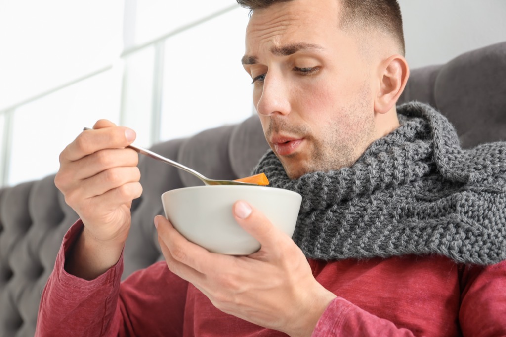 Man is sick in bed with some soup.