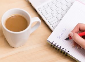 Woman being productive and writing a to-do list, ways to feel amazing