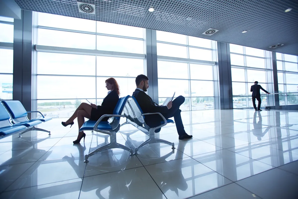 two people sitting in an empty airport