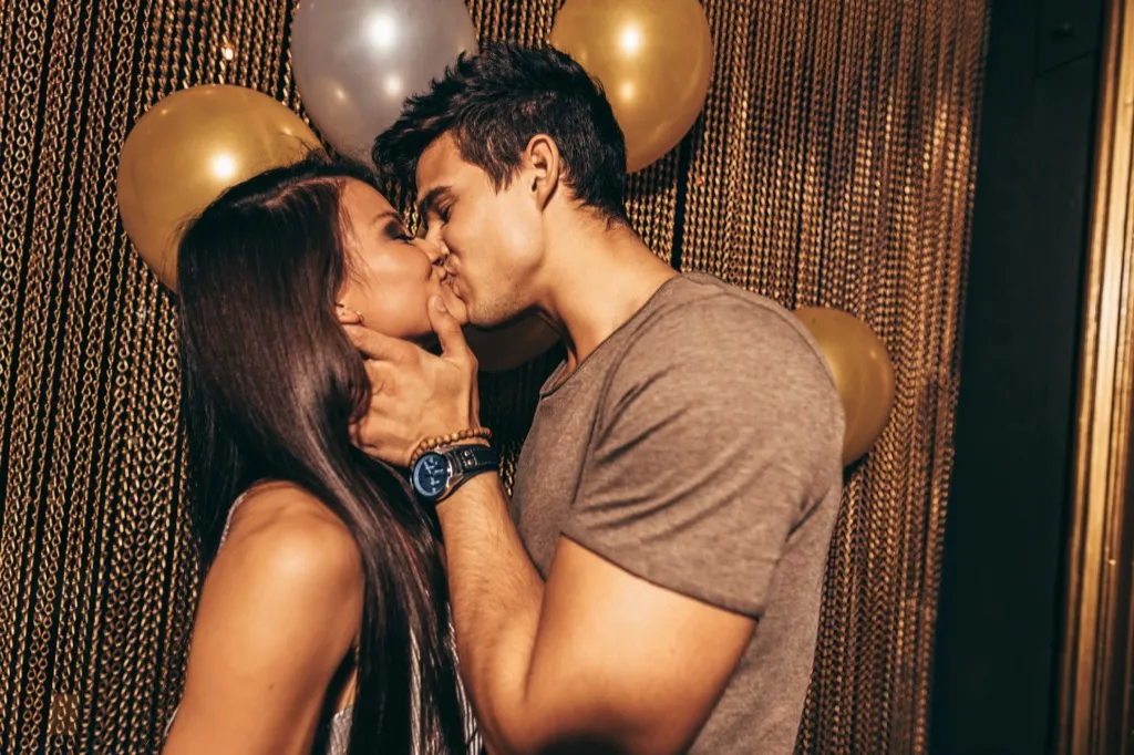 couple kissing in front of balloons