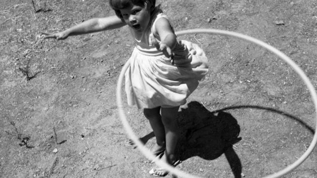 little girl using a hula hoop in the 1950s