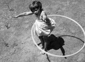 little girl using a hula hoop in the 1950s