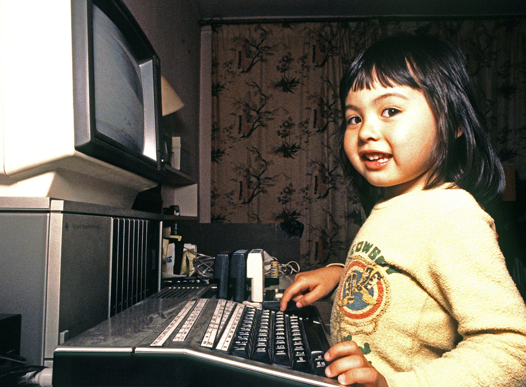 Three year old girl plays with a TI 99 4a home computer, 1986. California, USA. 