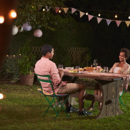 young black couple having dinner outside in garden